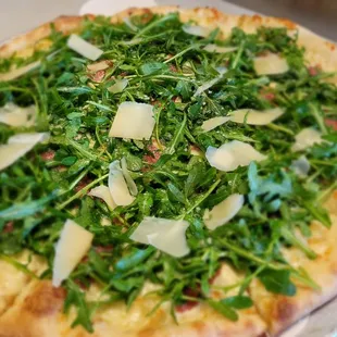 a pizza topped with arugula and cheese