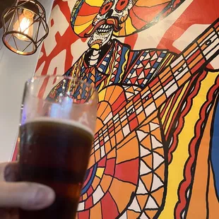 a hand holding a pint of beer