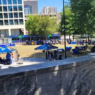 a view of a fountain with blue umbrellas