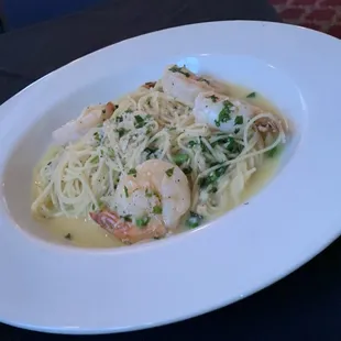 a plate of pasta with shrimp and spinach