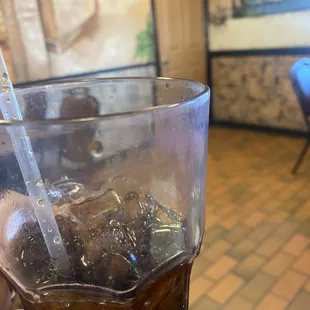 a hand holding a glass of soda