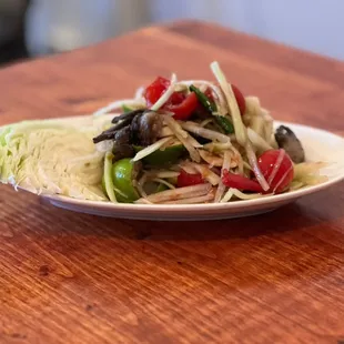 Lao Papaya Salad (Tum Lao) Spicy hand pounded green papaya, rice field salted crab, "Pla Lha" anchovy dressing, Thai eggplant, cherry tomato
