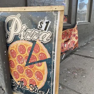 a pizza sign on a sidewalk