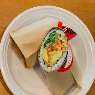 a burrito wrapped in paper on a plate