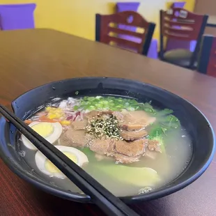 a bowl of ramen with chopsticks