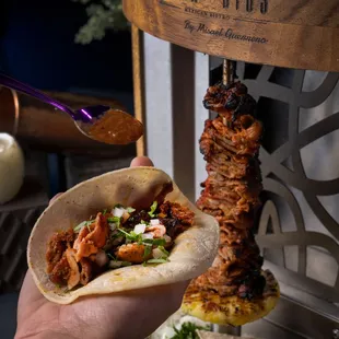 a hand holding a taco