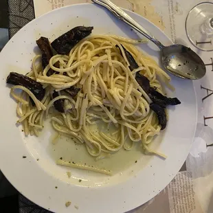 Pasta with garlic and olive oil topped with grilled portobello mushrooms