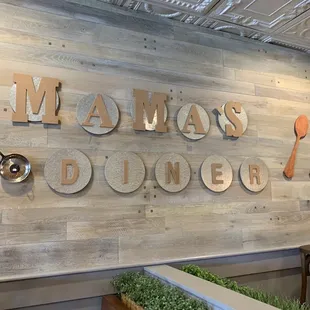 a wooden wall with a sign that says mama's diner