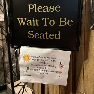 a sign that reads please wait to be seated