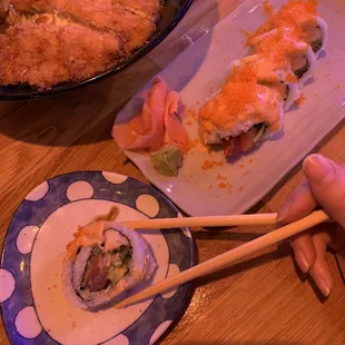 a plate of sushi and chopsticks
