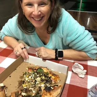 a woman cutting a pizza