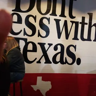 a woman sitting in a chair in front of a sign that says don't mess with texas