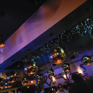 a bar with disco balls hanging from the ceiling