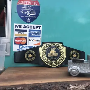 Their Mac and Cheese Throwdown Belt and their payment methods.