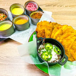 Crispy green plantain fritters accompanied with bean dip, avocado, cheese, pico de gallo, and house salsa.