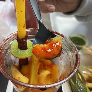 a person holding a spoon over a bowl of food