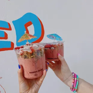 two women holding up cups of ice cream