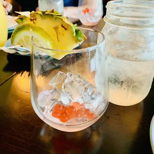 a glass of water with a pineapple garnish
