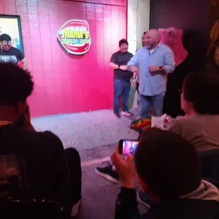 a group of people standing in front of a pink wall