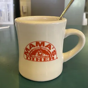 a coffee mug with a spoon in it