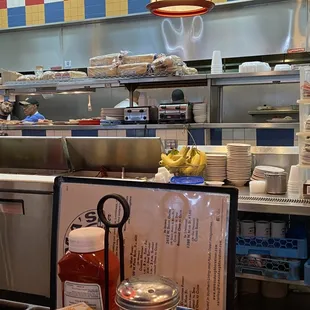 Busy kitchen, sitting at the counter is fun, free entertainment.