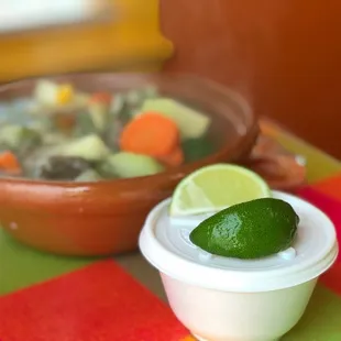 a bowl of soup and a lime