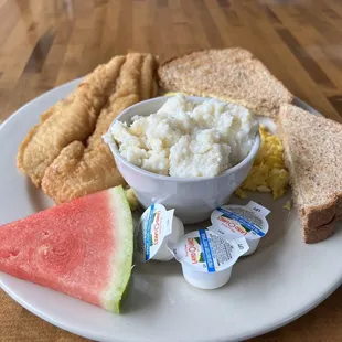 a plate of food including bread, eggs, and watermelon