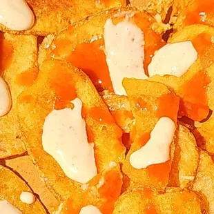 House chips topped with hot sauce and ceasar dressing.