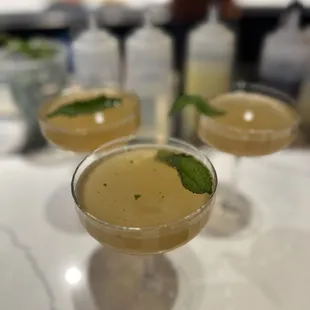 three cocktails with mint garnish