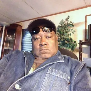 a man wearing a denim jacket and sunglasses