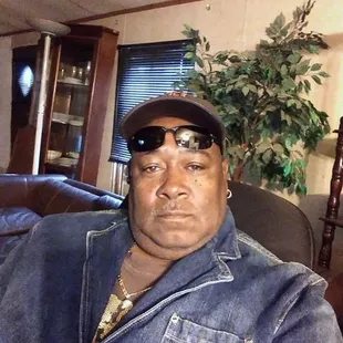 a man wearing sunglasses and a denim jacket