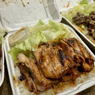 two takeout containers with chicken and rice