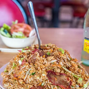a plate of fried rice and a bottle of water