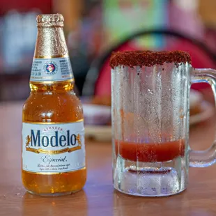 a glass of beer and a bottle of beer on a table