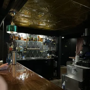a bar counter with a lot of bottles on it