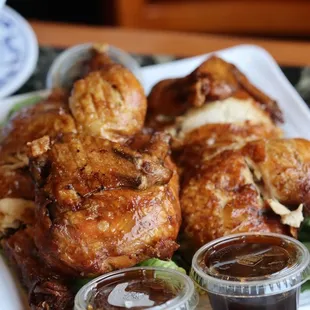 a plate of chicken wings with dipping sauces