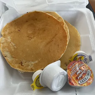 two pancakes in a styrofoam container