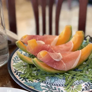 a plate of melon slices and a glass of water