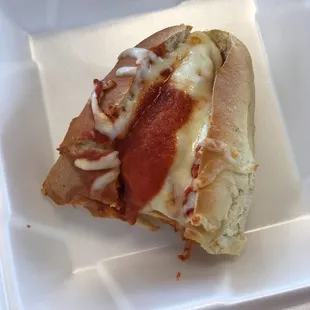 a slice of pizza on a styrofoam plate