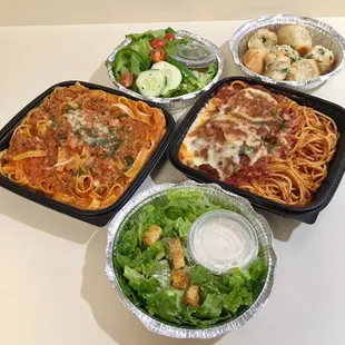 Fettuccine Bolognese $16 (left) and Chicken Parmesan $20 (right) served with salads and garlic rolls