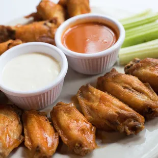 a plate of chicken wings with dipping sauce