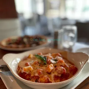 a closeup of a bowl of pasta and a glass of water