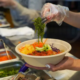 a person holding a bowl of food