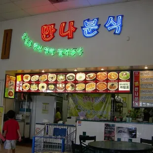 a woman and child walking in front of the restaurant