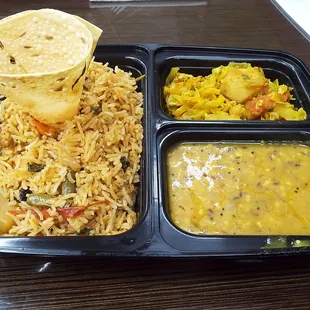 Vegetable thali: on the left, vegetable biryani with papadum cone; top right, dry curry of potatoes and cabbage; bottom right, sambar.