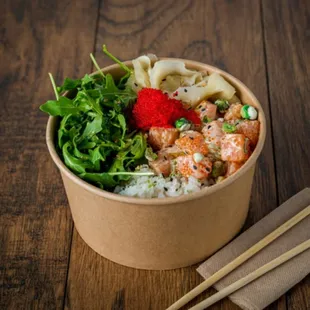 a bowl of food with chopsticks