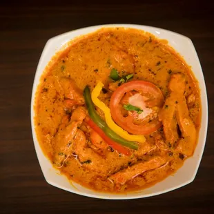 a bowl of curry with shrimp and vegetables