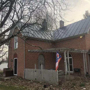 a brick house with a flag on the porch