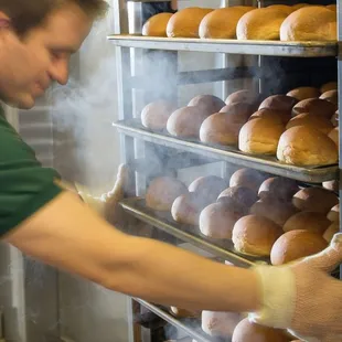 a man putting bread into a rack
