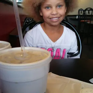 a young girl sitting at a table